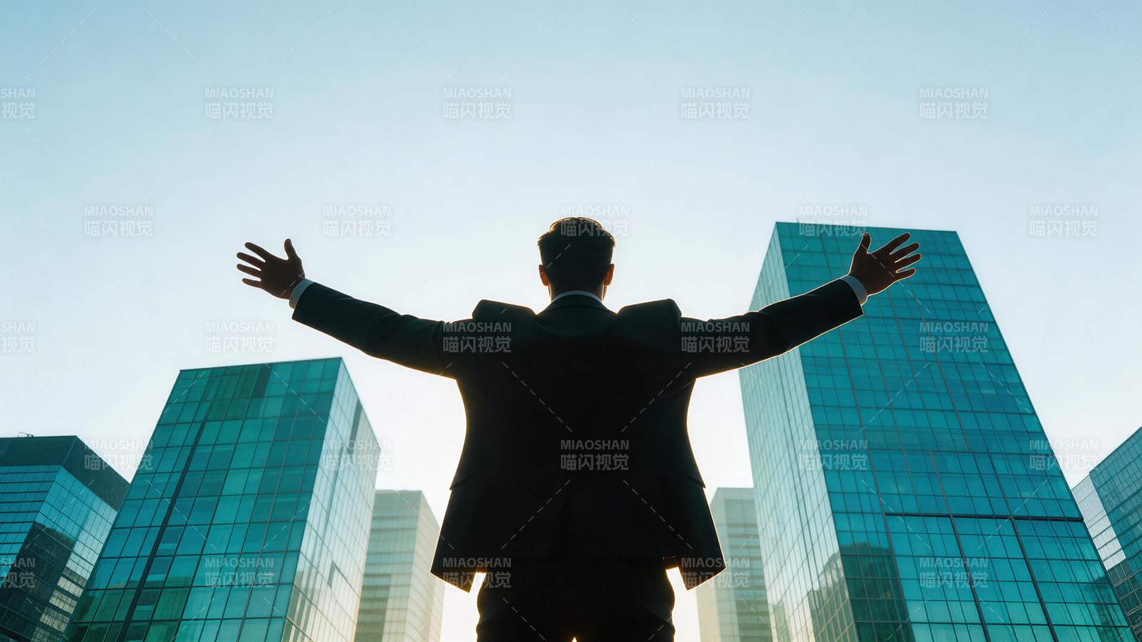 西装男子背对镜头张开双臂面对高楼群图片