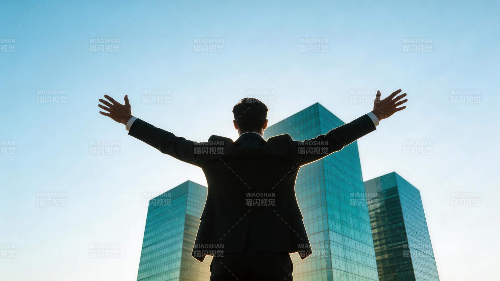 西装男子背对镜头张开双臂面对高楼图片