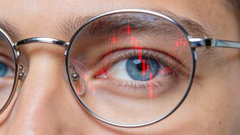 戴眼镜者眼中映射红色股票K线图图片