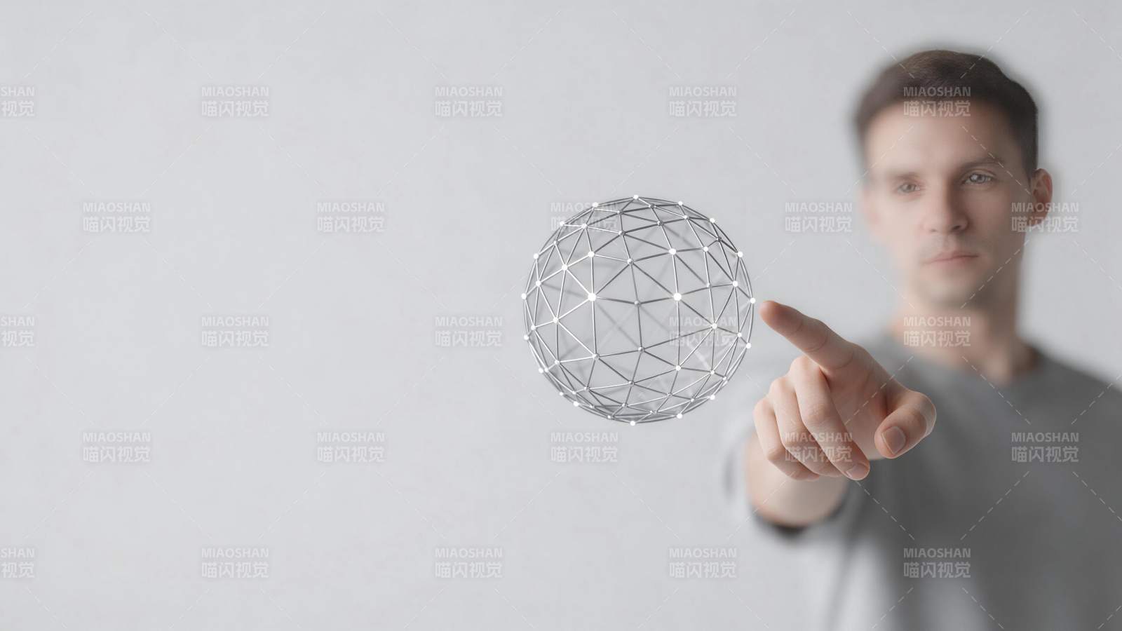 男子手指触碰悬浮金属网格球体图片