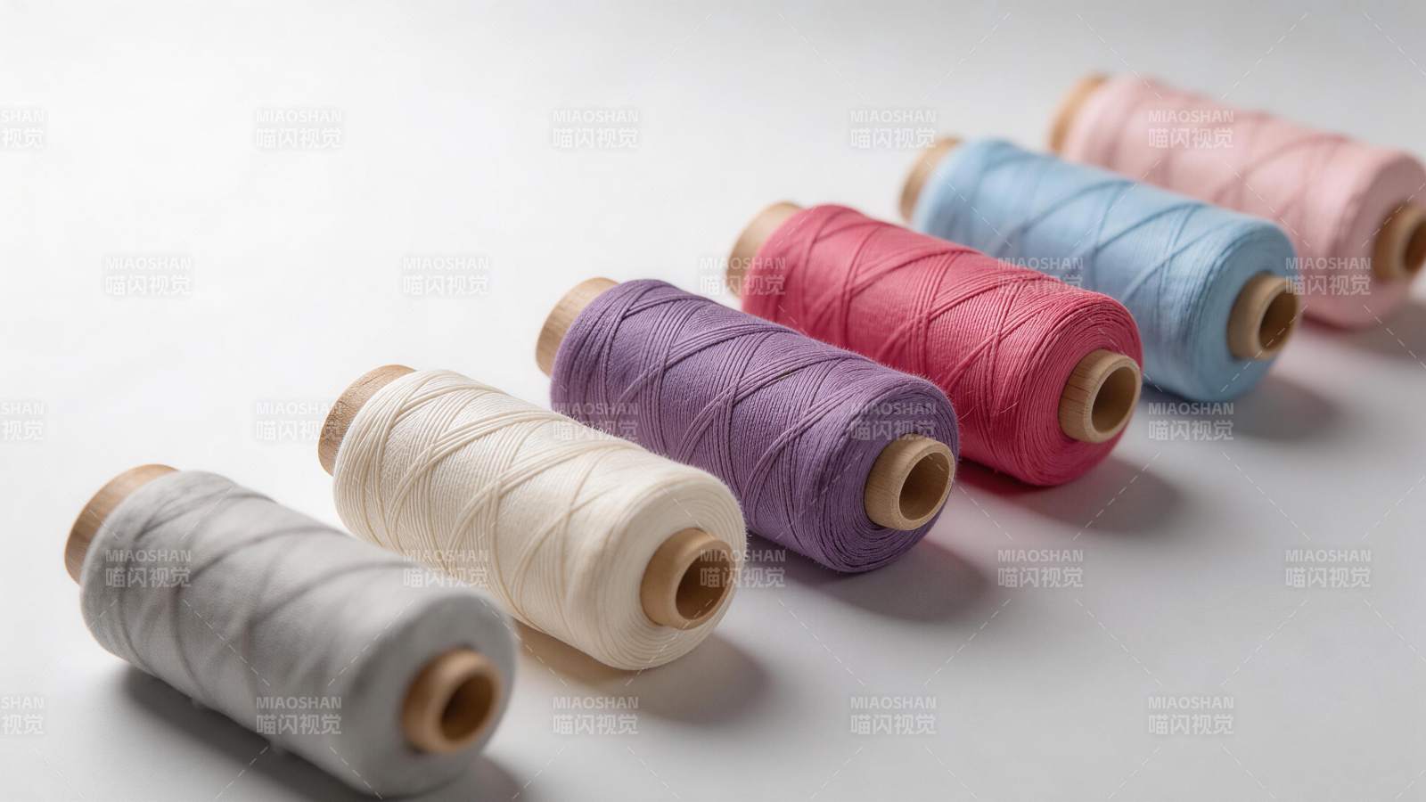 六卷彩色棉线整齐排列在白色背景上图片