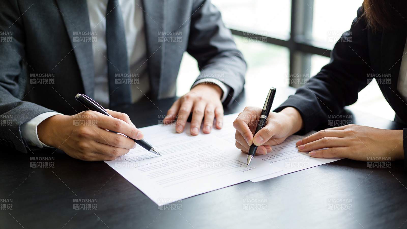 两人正签署文件协议的商务签约场景图片
