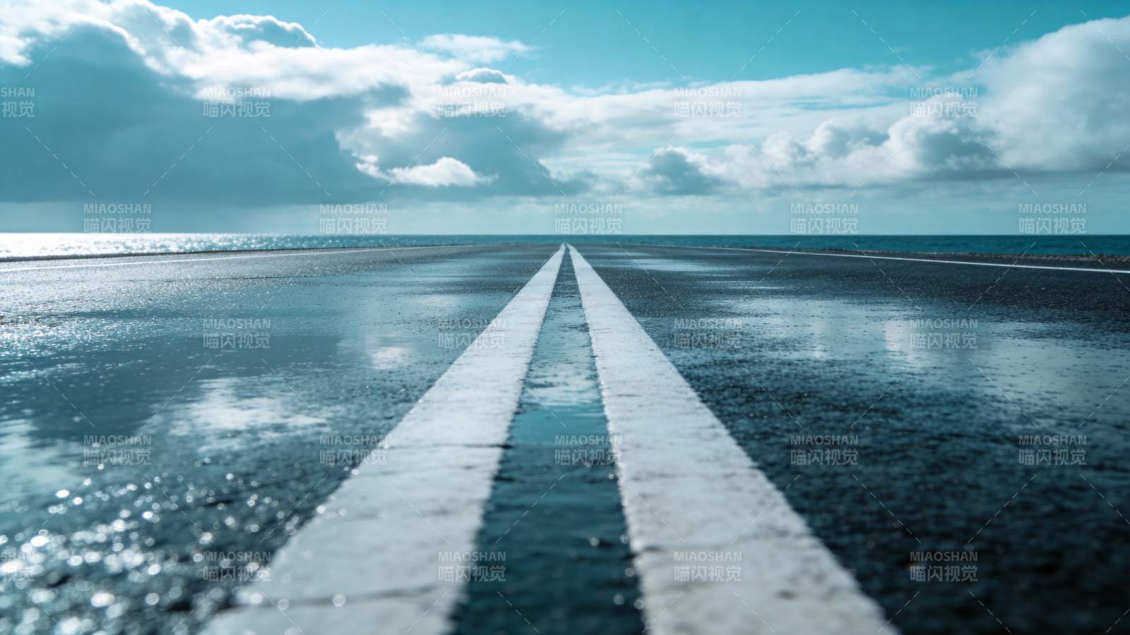 湿漉漉的柏油路延伸至海天交界处图片