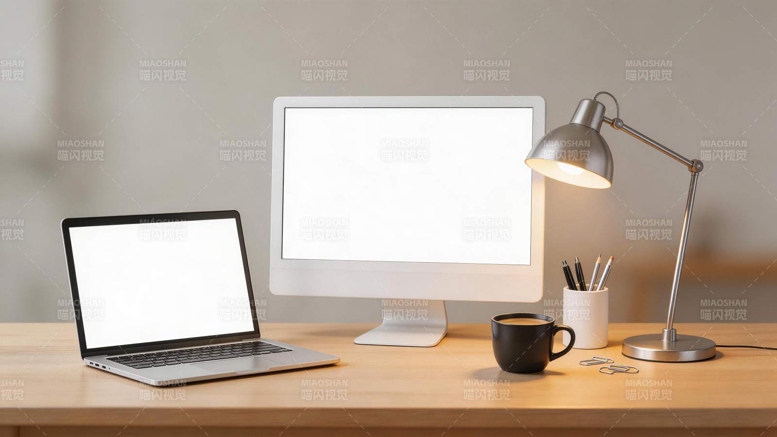 木质桌面上摆放笔记本电脑显示器台灯与文具图片