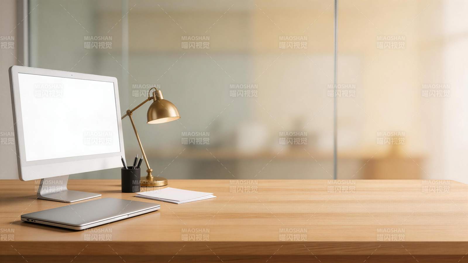 木质办公桌上摆放电脑显示器与台灯图片