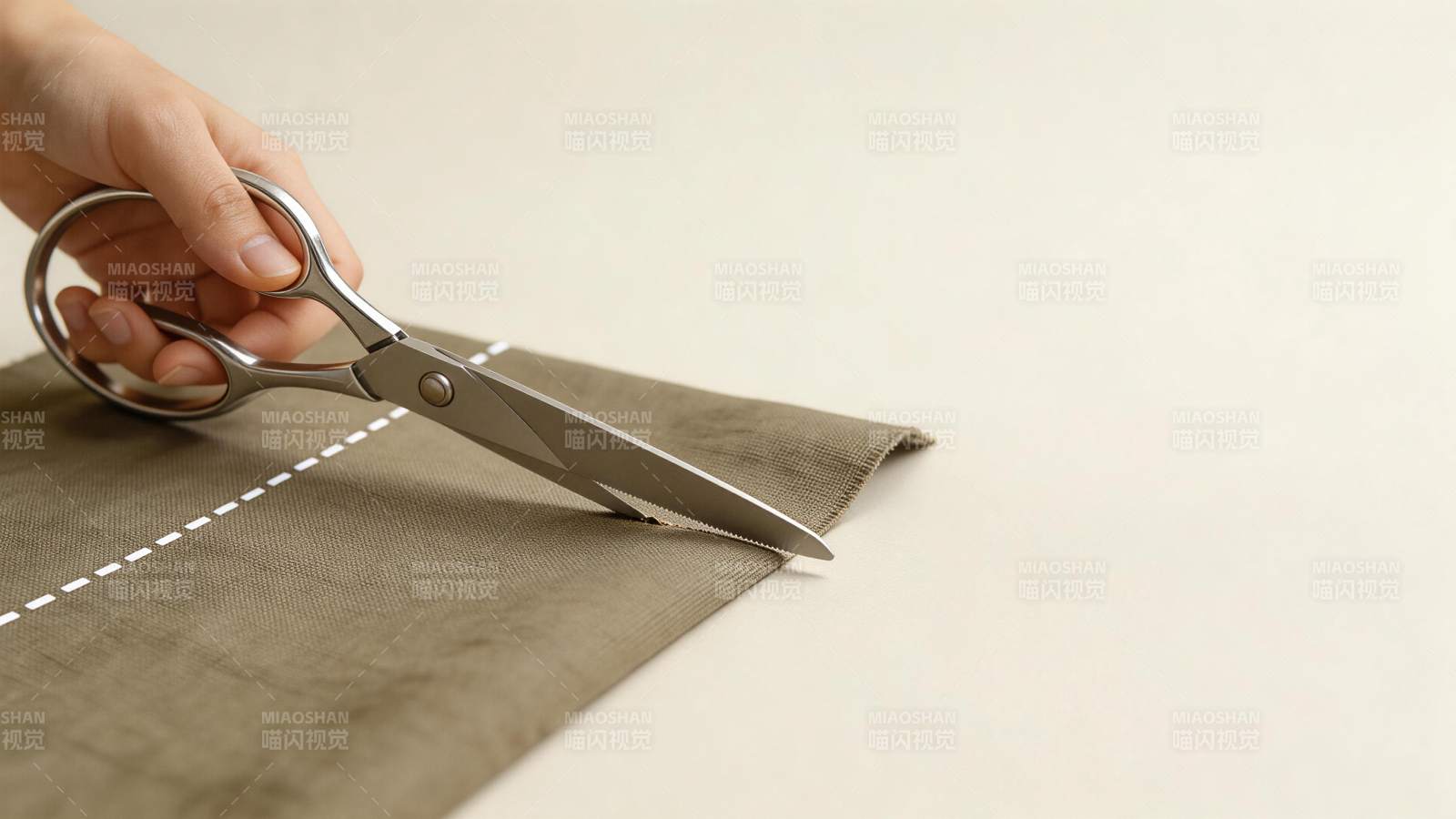 手持剪刀裁剪带有虚线标记的布料图片