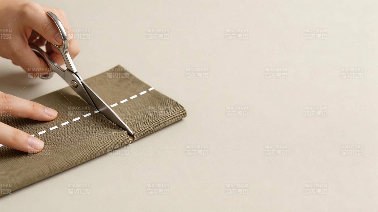 手持剪刀沿虚线裁剪布料的特写画面图片