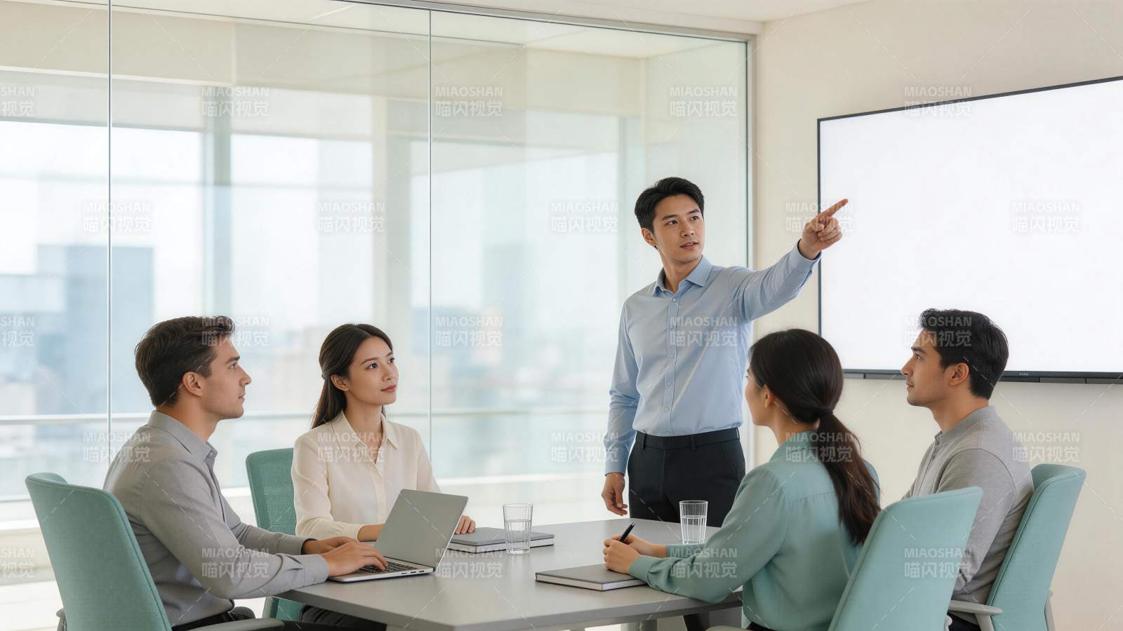 会议室中男性站立指向屏幕进行工作汇报图片