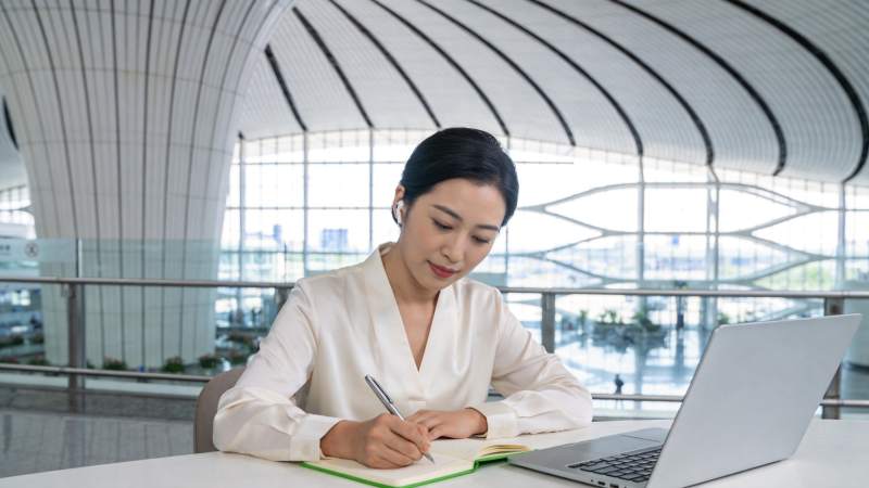 女性在现代化室内空间使用笔记本电脑记录笔图片