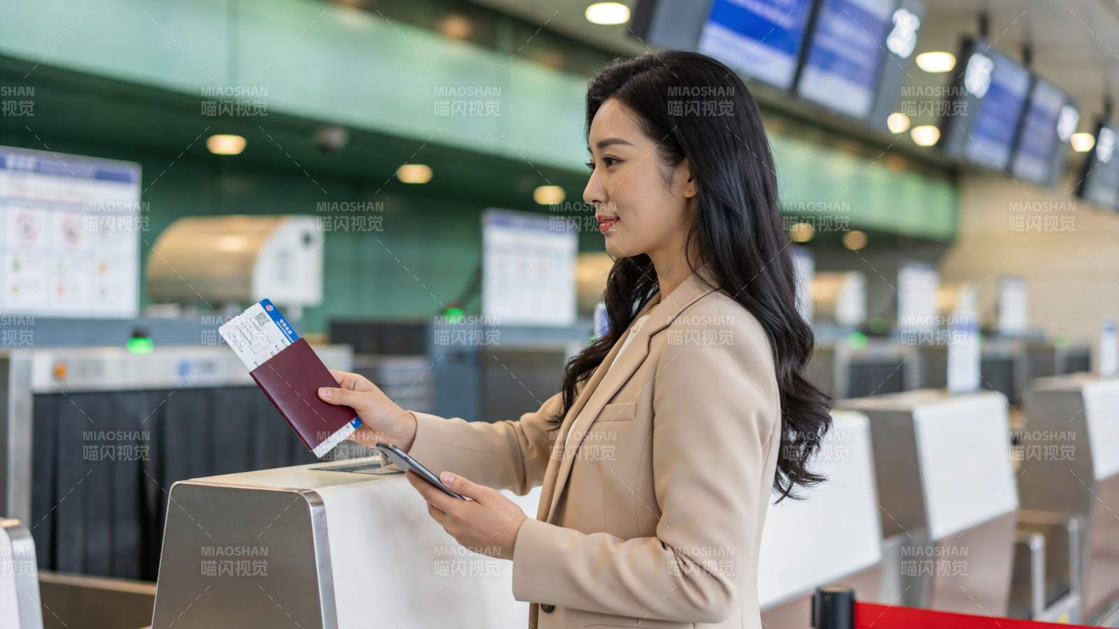 女性旅客在机场值机柜台办理登机手续图片