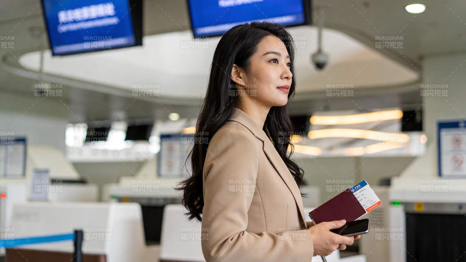 机场值机柜台前持护照登机牌的女性旅客图片
