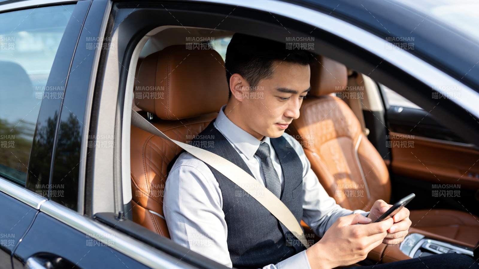 男士车内系安全带使用手机场景图片