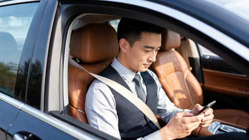 男士车内系安全带使用手机场景图片