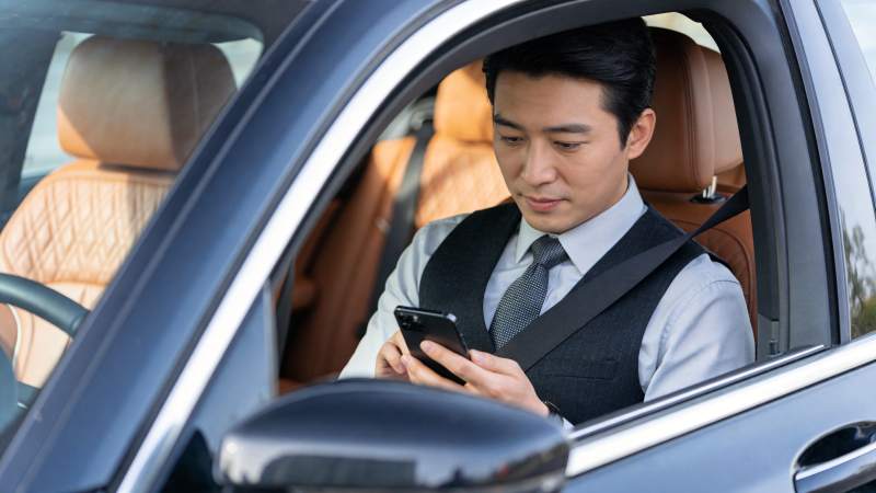 男士坐在车内专注使用智能手机图片