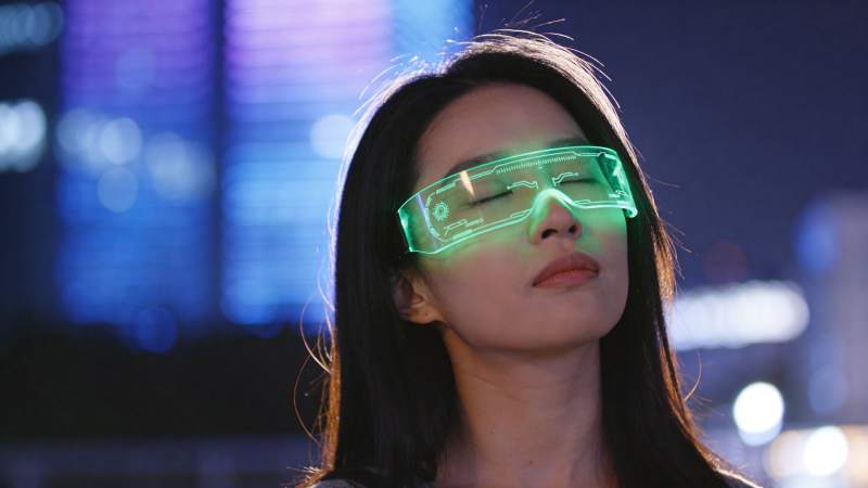 佩戴绿色发光智能眼镜的女性夜景特写图片