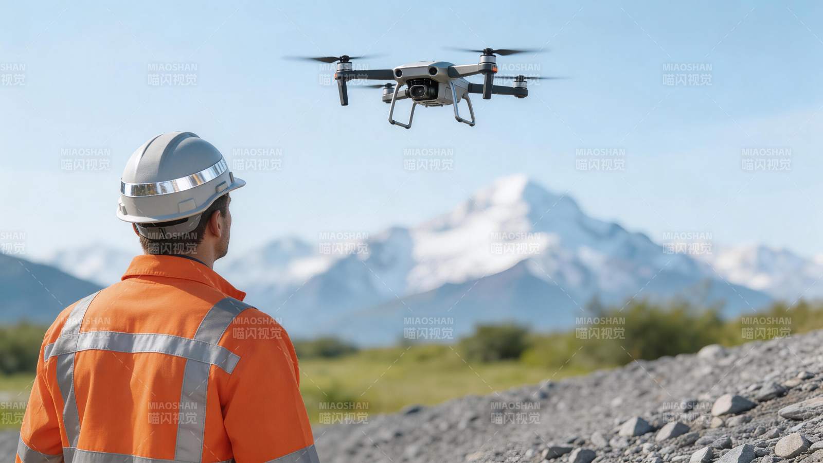 工人佩戴安全帽操控无人机进行野外作业图片