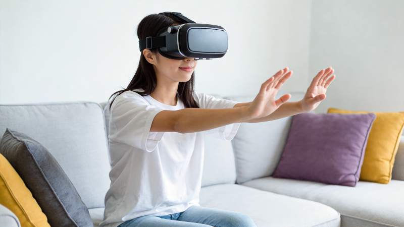 女性佩戴VR设备在沙发前进行虚拟现实交互图片