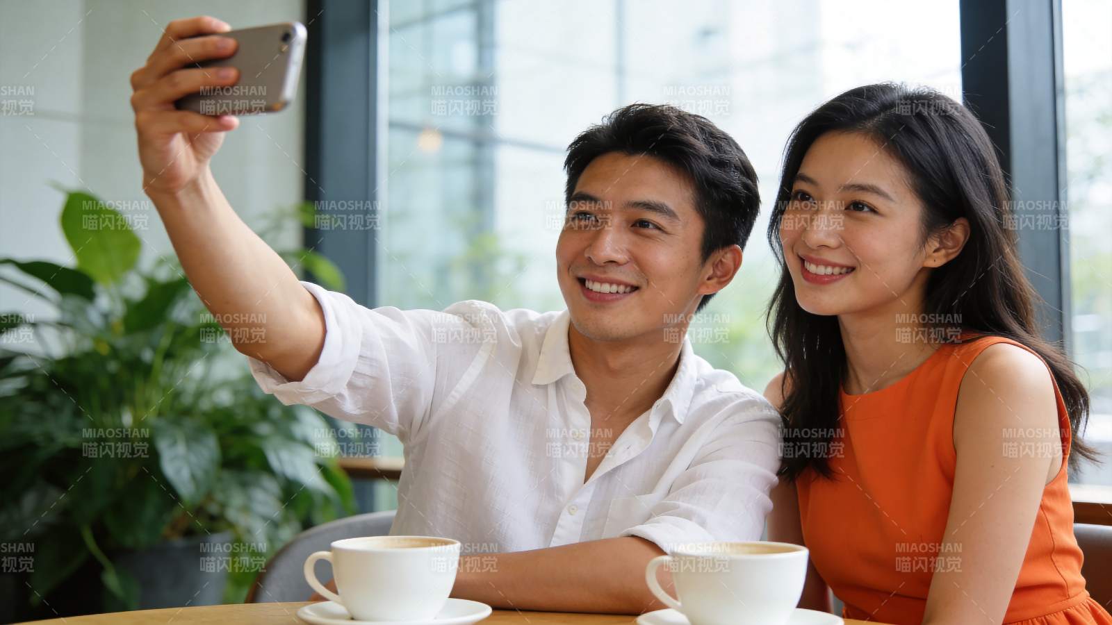 男女在咖啡馆用手机自拍合影图片