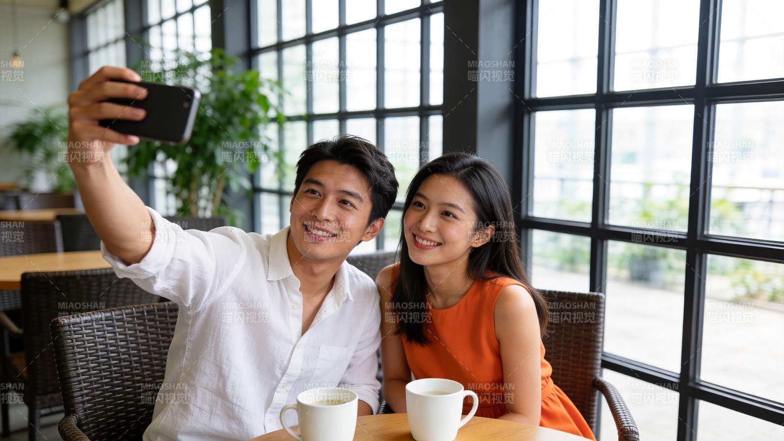 男女在咖啡馆用手机自拍合影图片