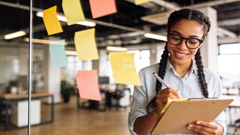 办公室女性手持写字板记录便签内容图片
