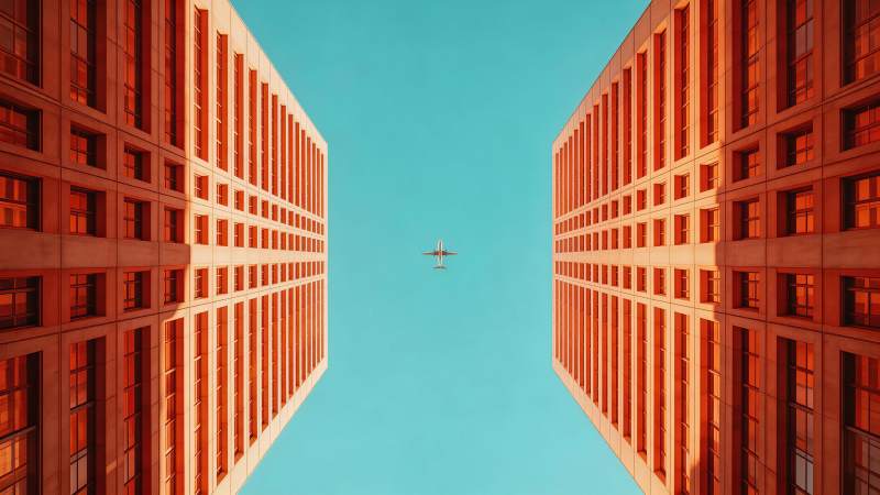 两栋高楼间飞行的客机仰视视角图片