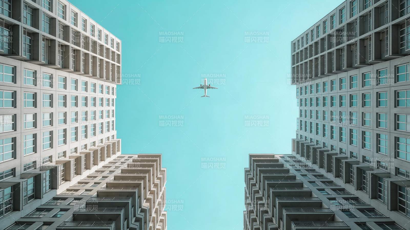 高楼之间飞行的客机仰视视角画面图片