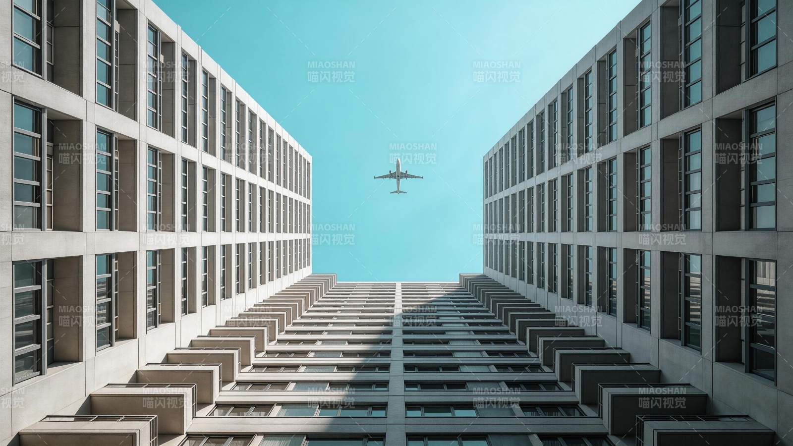 高楼夹缝中飞行的客机仰视视角图片