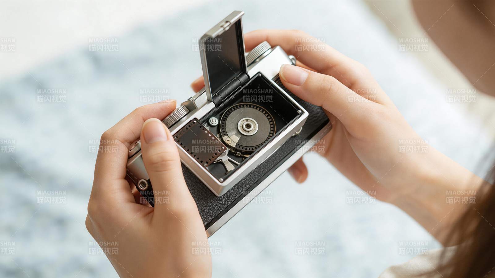 双手操作打开胶片相机后盖装胶卷图片