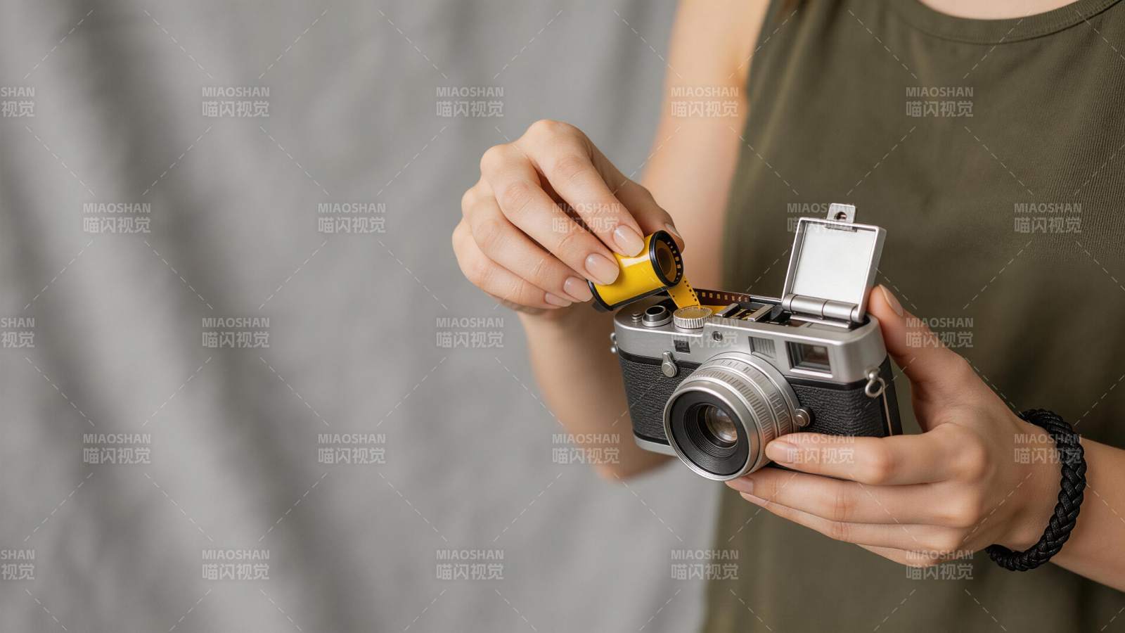 女子手持胶卷正装入复古相机中图片