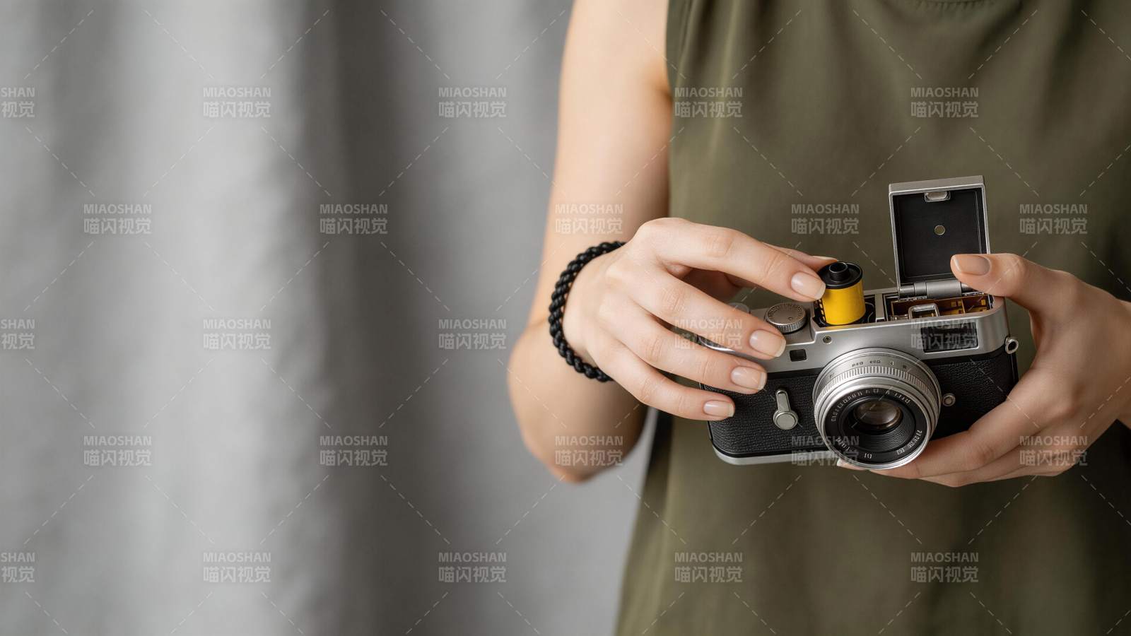 女子手持胶片相机装入黄色胶卷图片