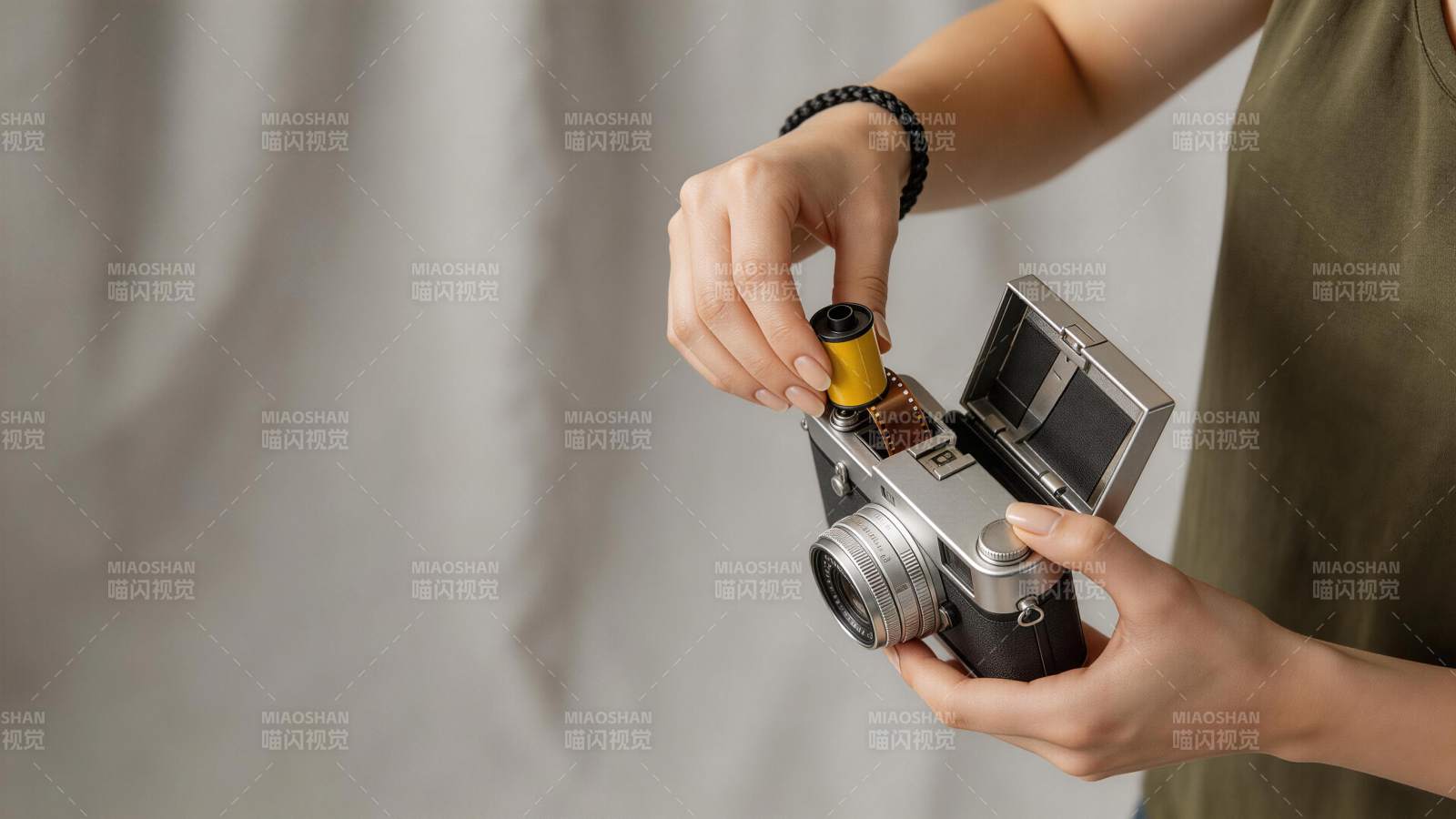 女性双手装入胶卷至复古相机中图片
