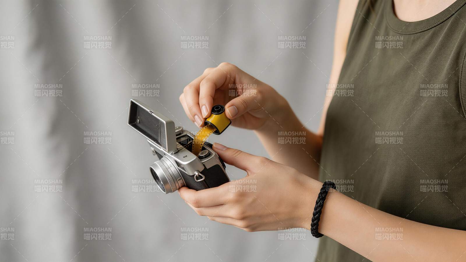 女子手持胶卷相机装入黄色胶卷图片