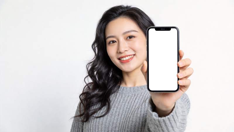 年轻女性手持白色屏幕智能手机展示图片
