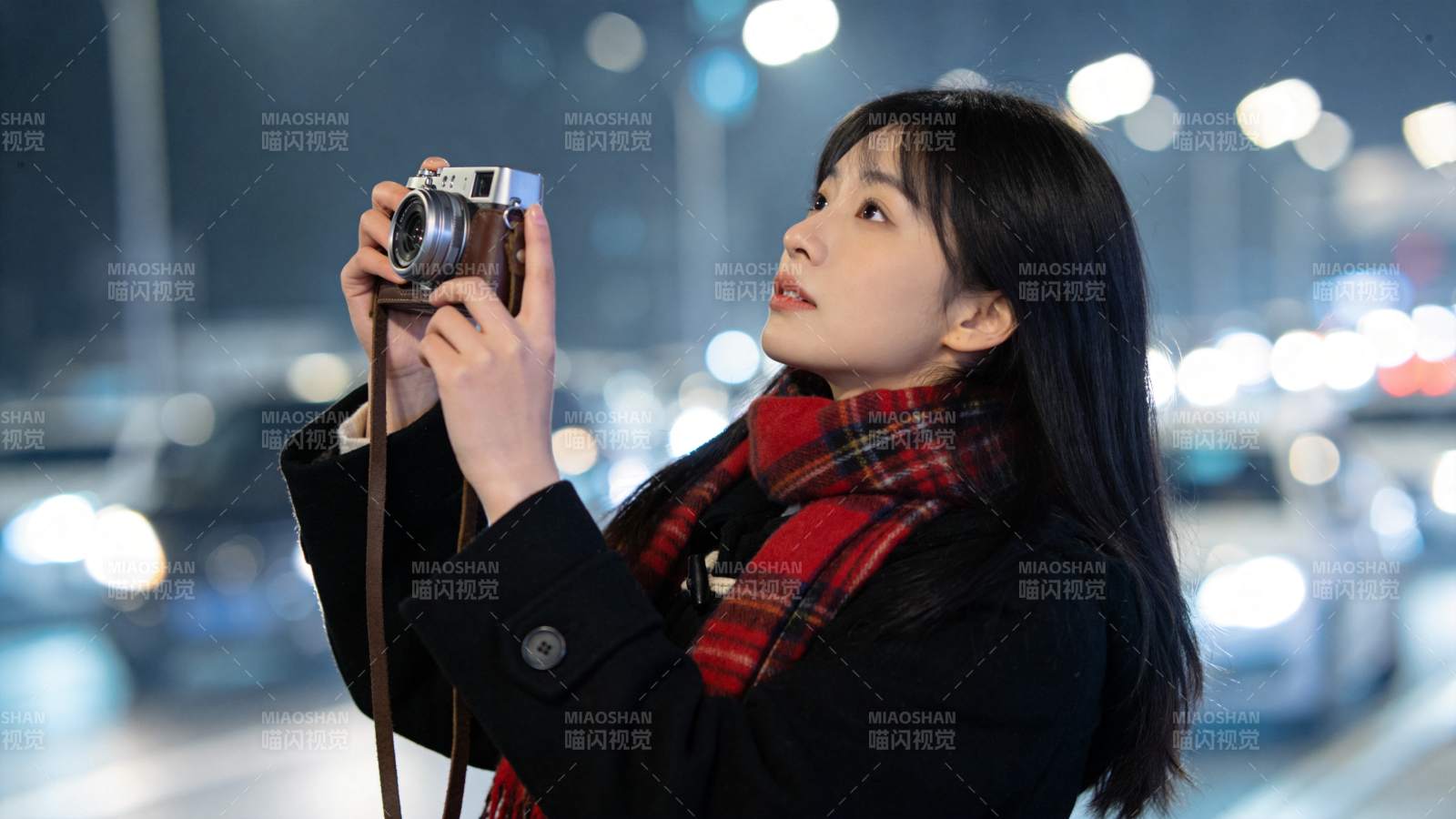 夜晚街头女子手持复古相机拍摄街景图片