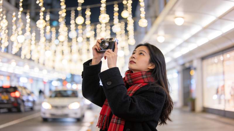 女子手持相机拍摄街景灯光装饰图片
