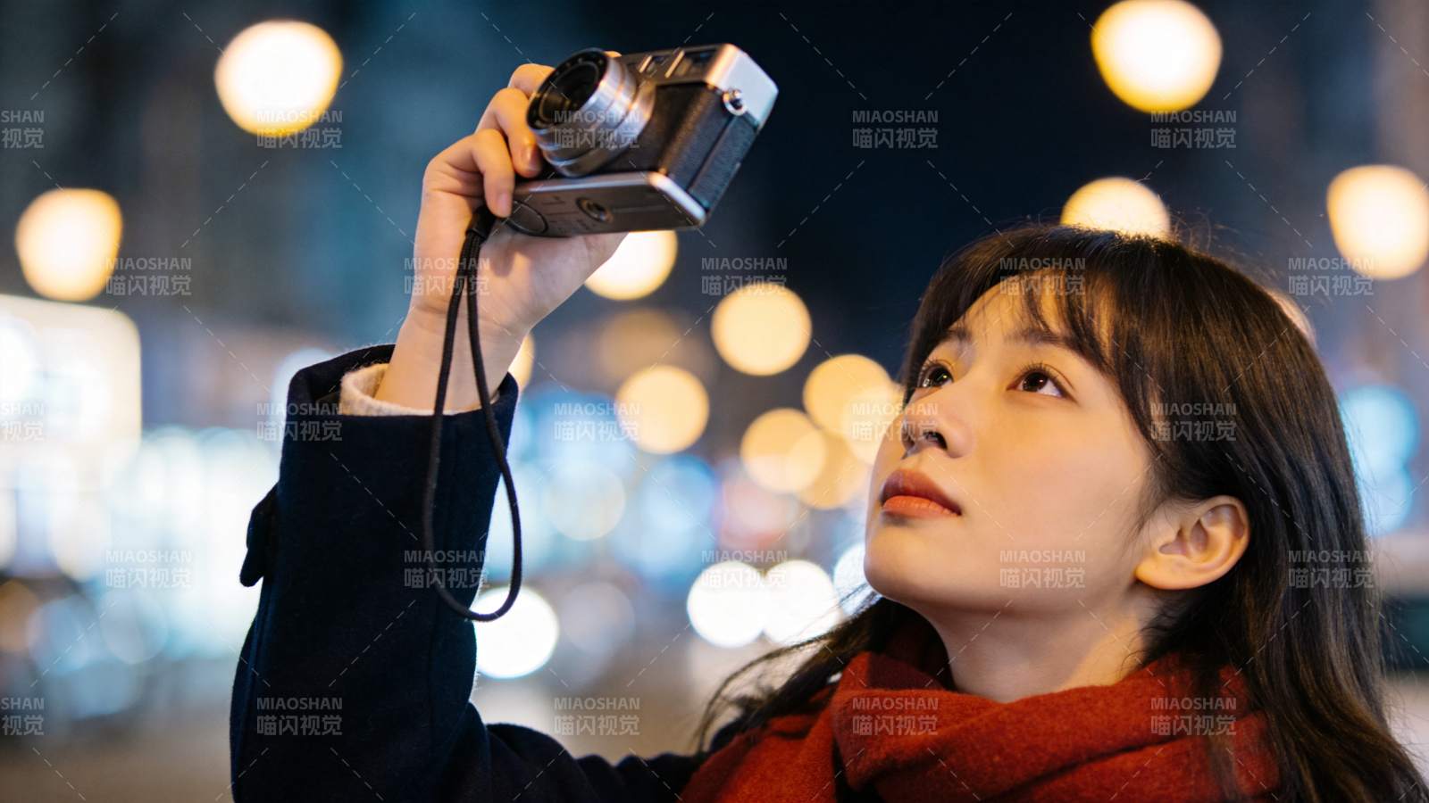 女子夜间手持胶片相机仰拍街景图片