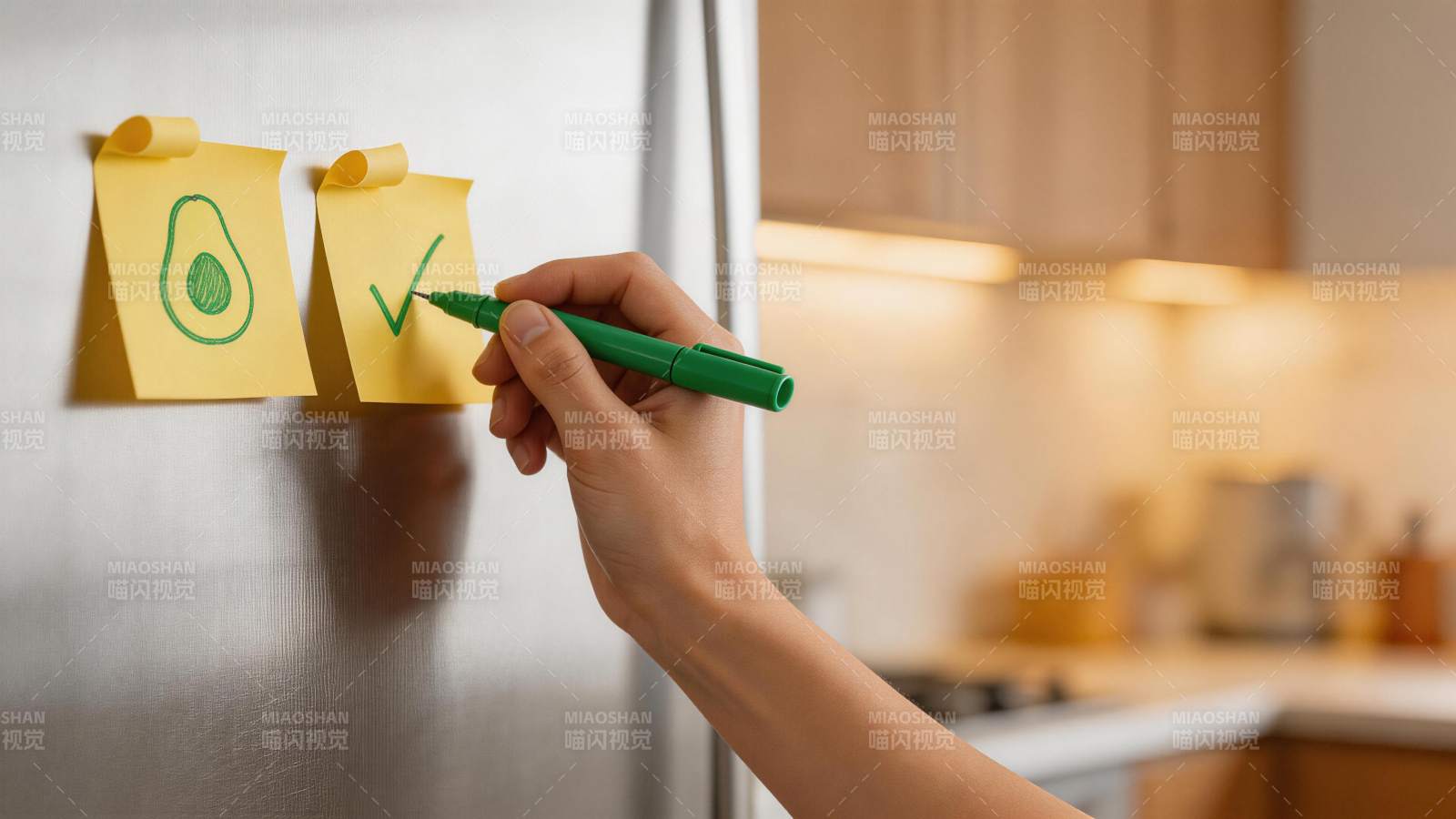 手用绿笔在冰箱贴纸上画对勾与牛油果图图片