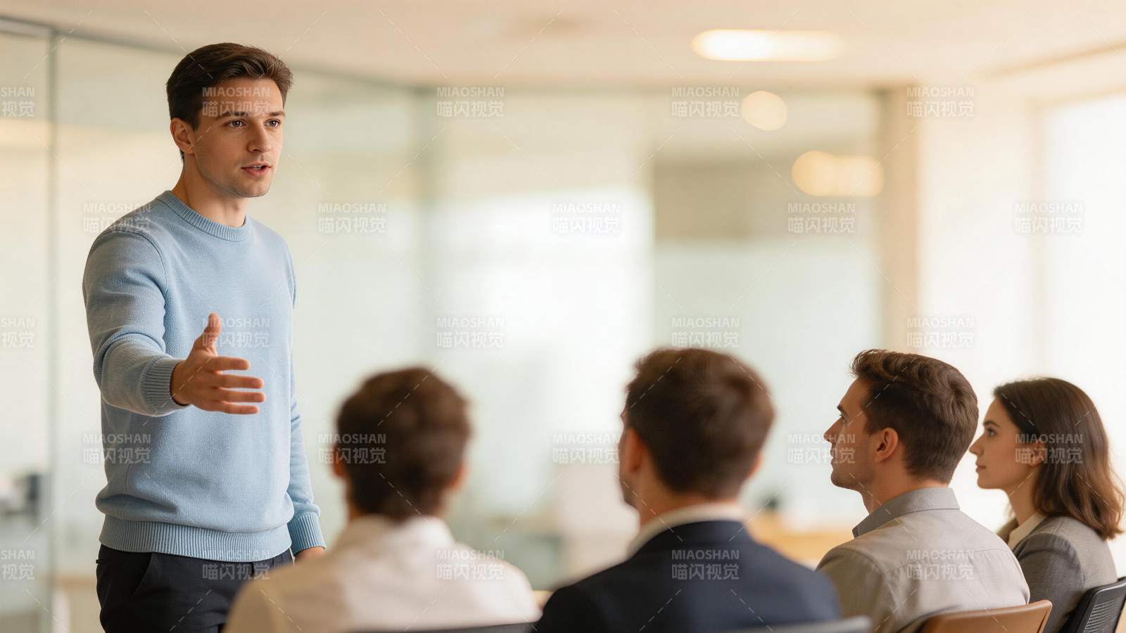 男士站立演讲面向四位听众交流场景图片