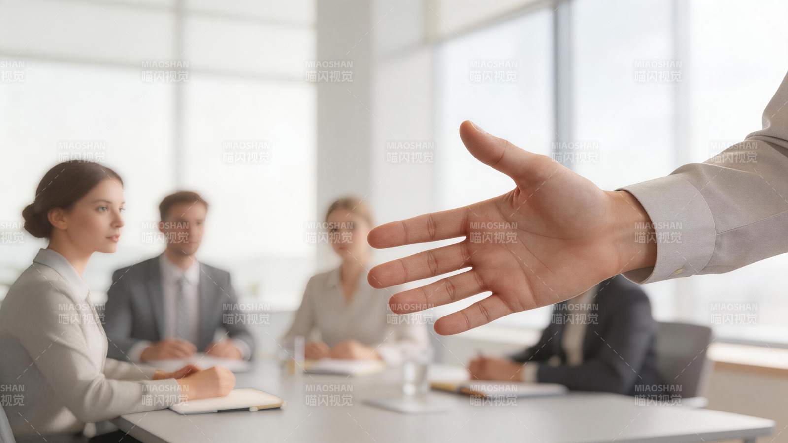 商务会议中主持人伸手示意讨论场景图片