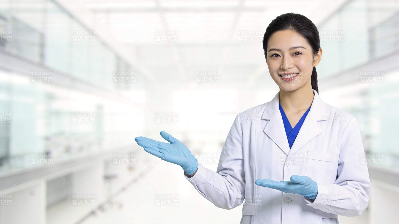 穿白大褂戴蓝手套的女性科研人员展示手势图片