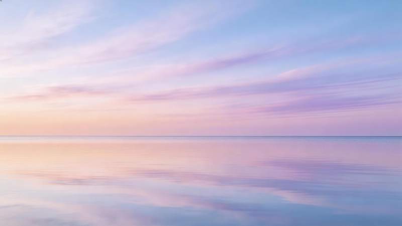 平静海面映照粉紫渐变晚霞天空图片