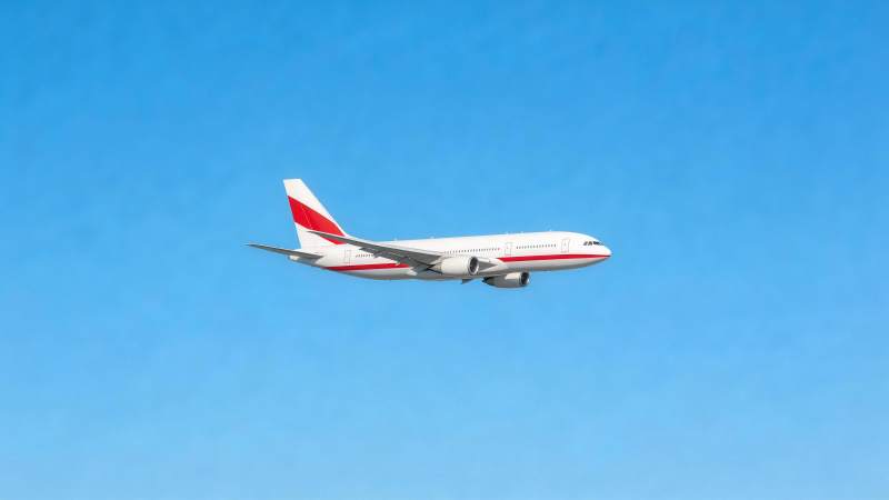 白色红尾客机在晴朗蓝天中飞行图片