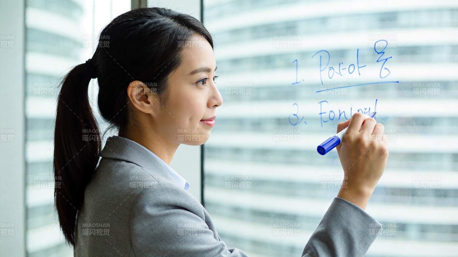 职场女性在玻璃板上书写英文笔记图片