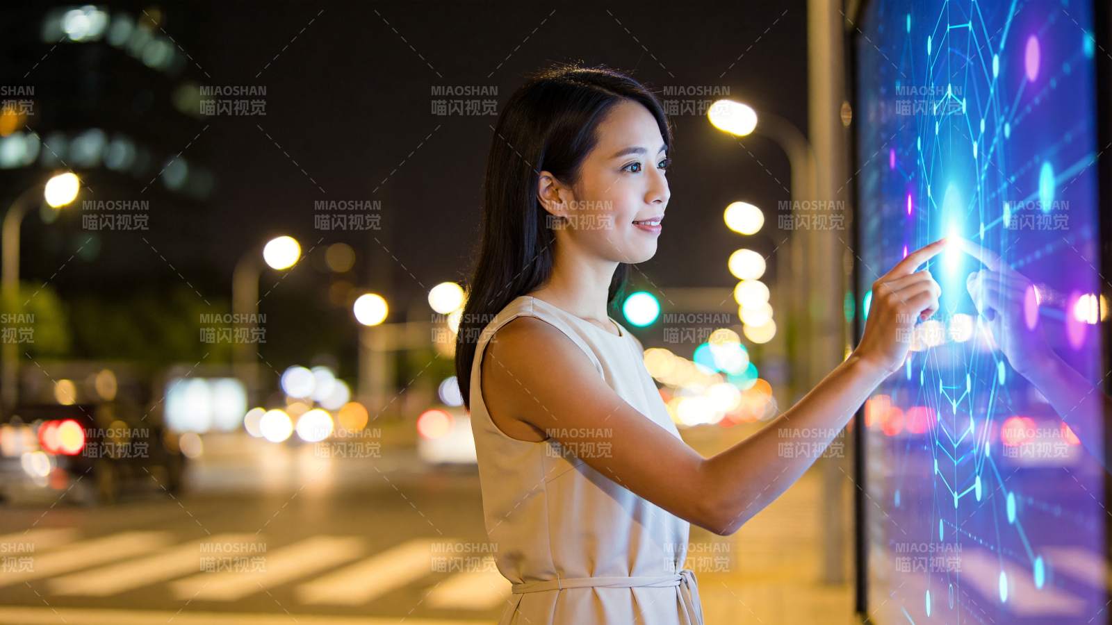 女性夜间街头触控互动数字屏幕图片