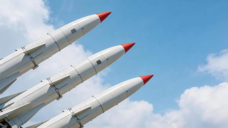 三枚白色导弹斜向排列指向蓝天背景图片