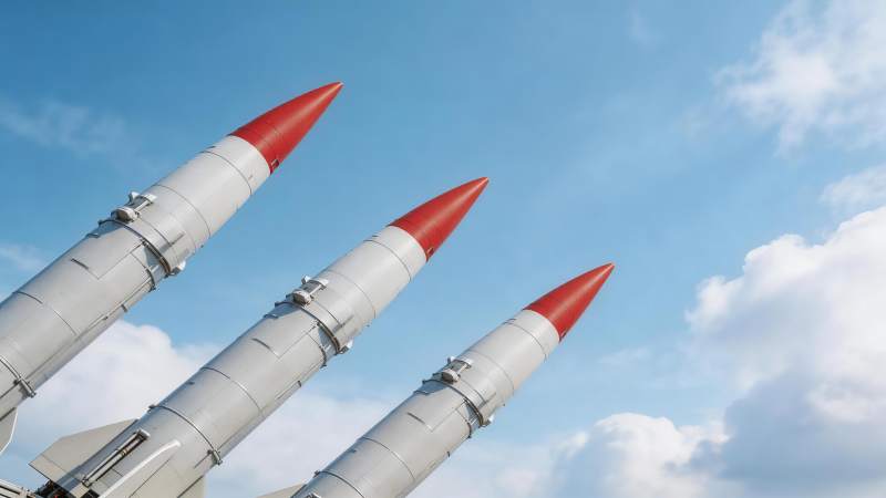 三枚红尖灰色导弹仰角排列于蓝天背景图片