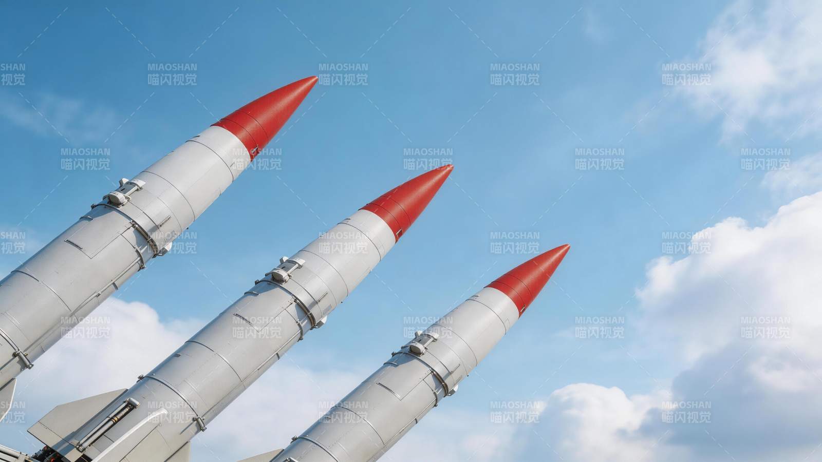 三枚红尖灰色导弹仰角排列于蓝天背景图片