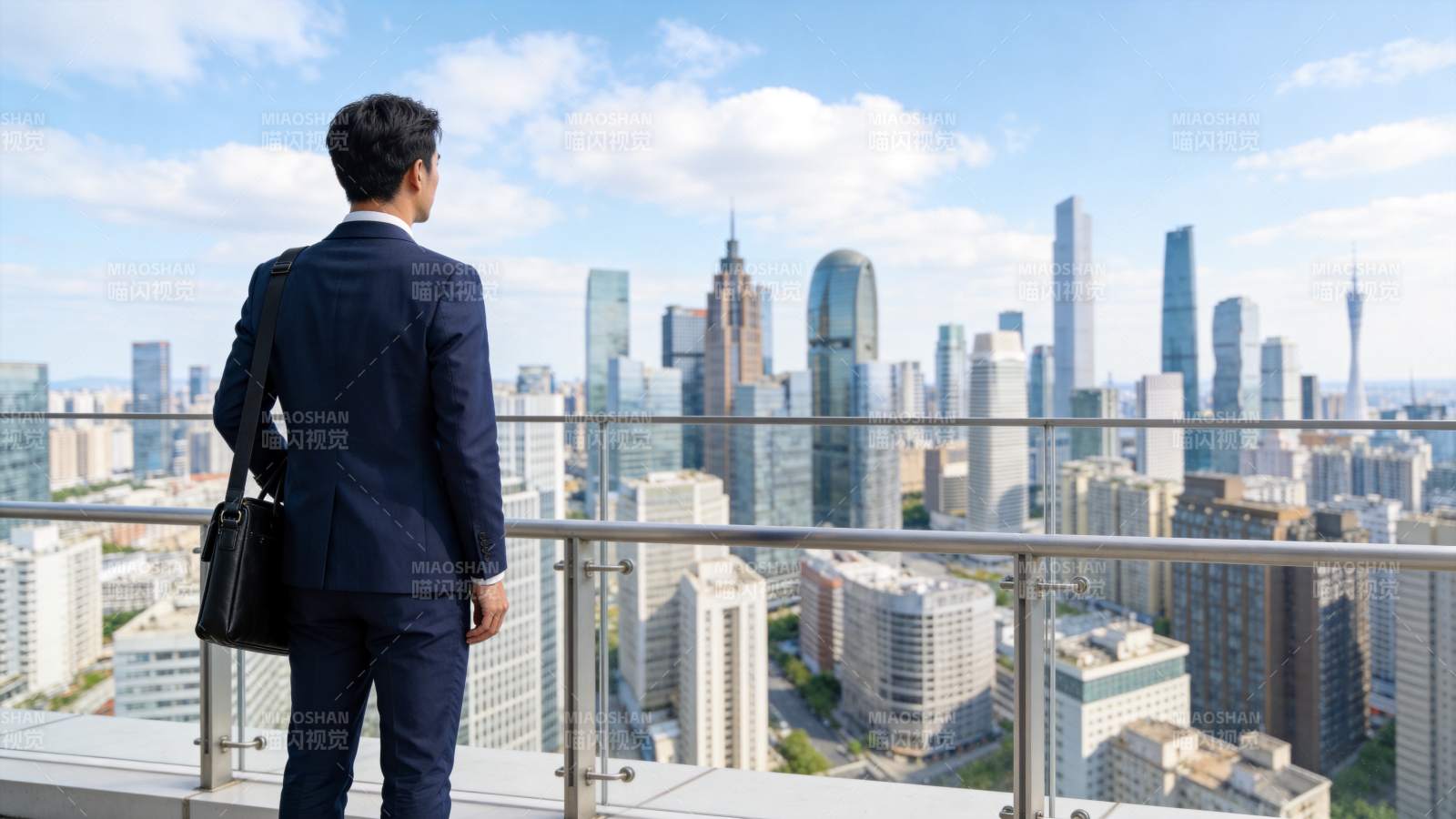 穿西装男子背对镜头眺望城市高楼群图片