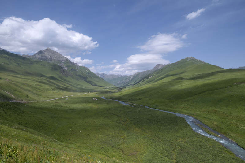 新疆伊犁孟克特古道蓝天白云映山谷溪流图片