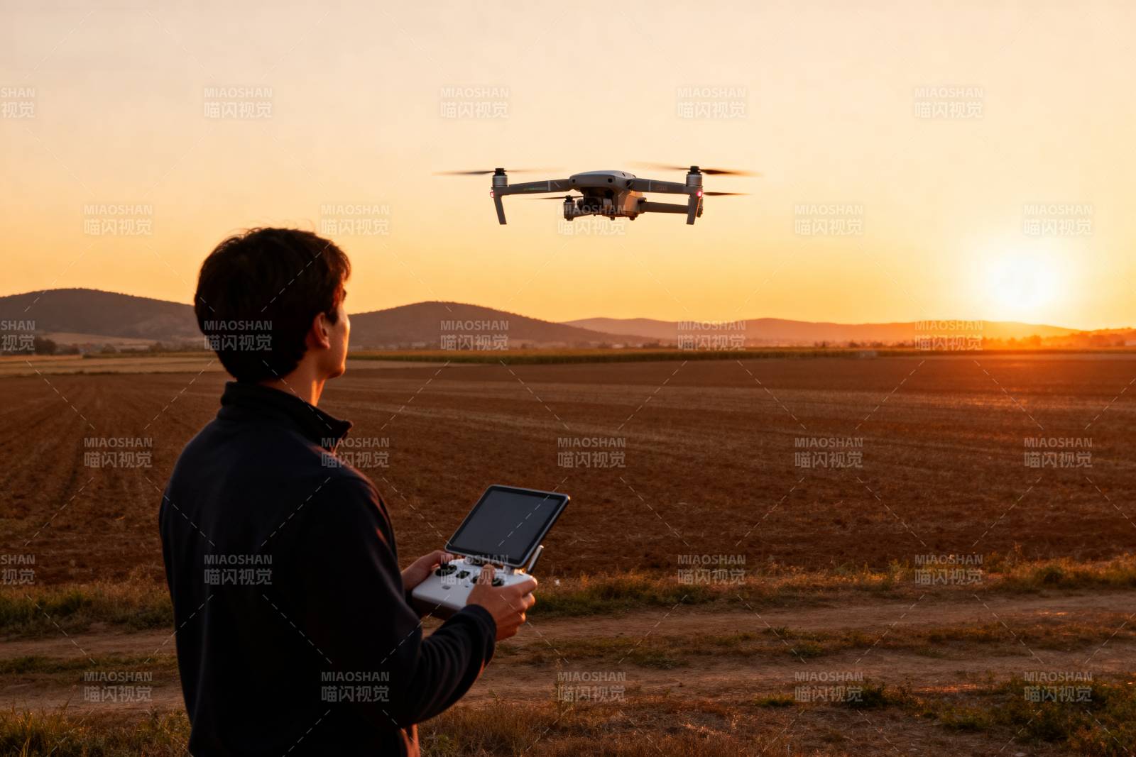 夕阳下操控无人机图片